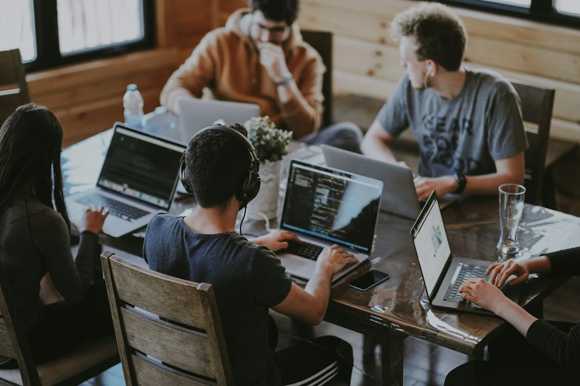 Equipe trabalhando em notebooks numa mesa compartilhada